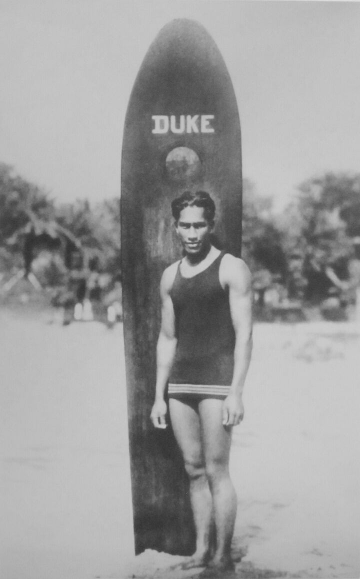 Duke Kahanamoku mit seinem Board aus massivem Holz, Anfang des 20. Jahrhunderts.